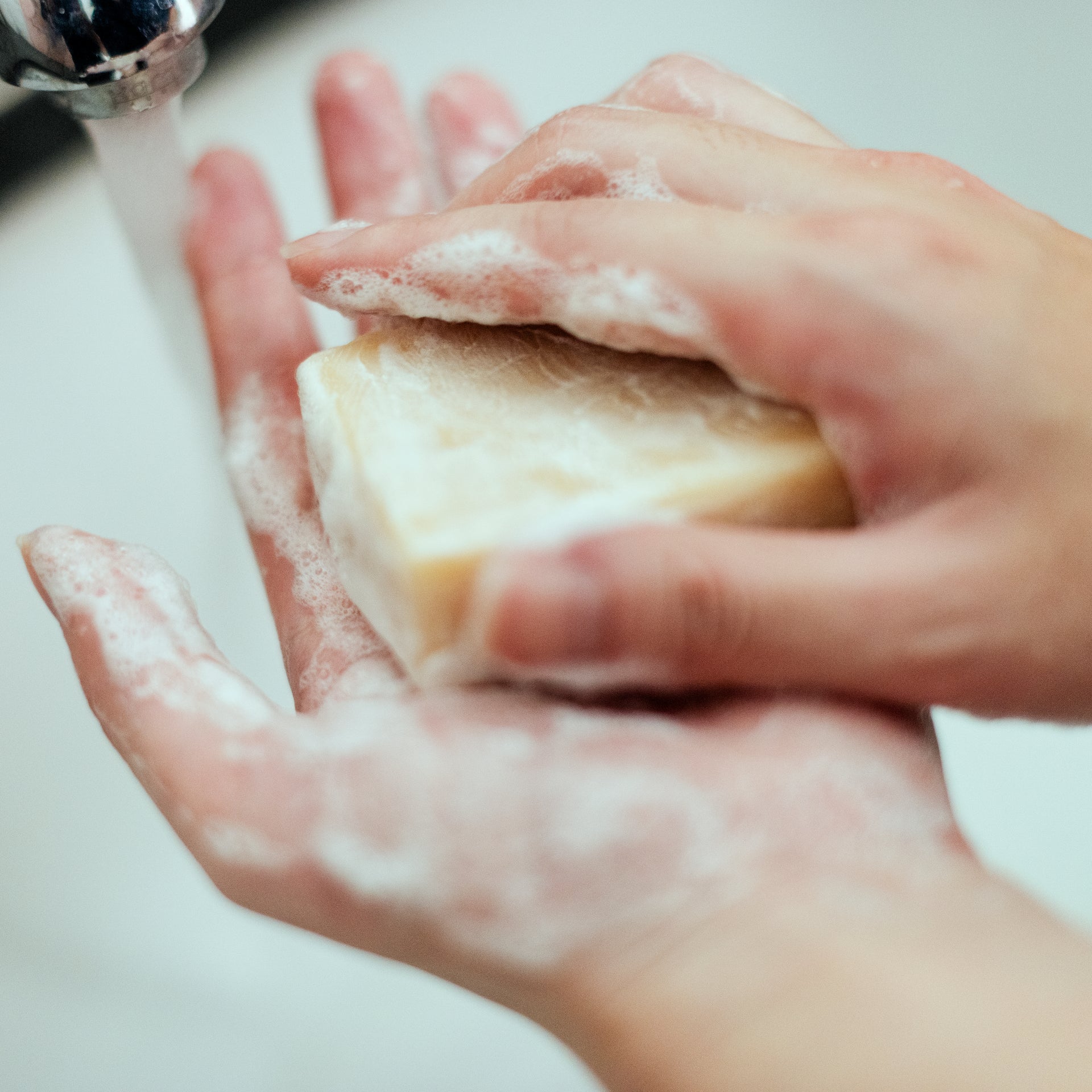 Persoon wast de handen met water tijdens een natuurlijke verzorgingsroutine.