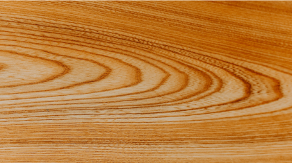 Close-up van een natuurlijk houten oppervlak met zichtbare houtstructuur.