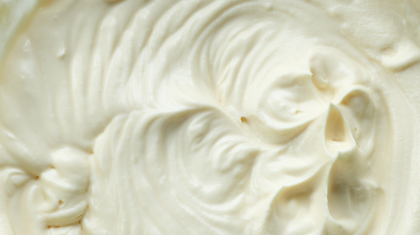 Close-up van de romige textuur van een Primal Glow tallow balsem.