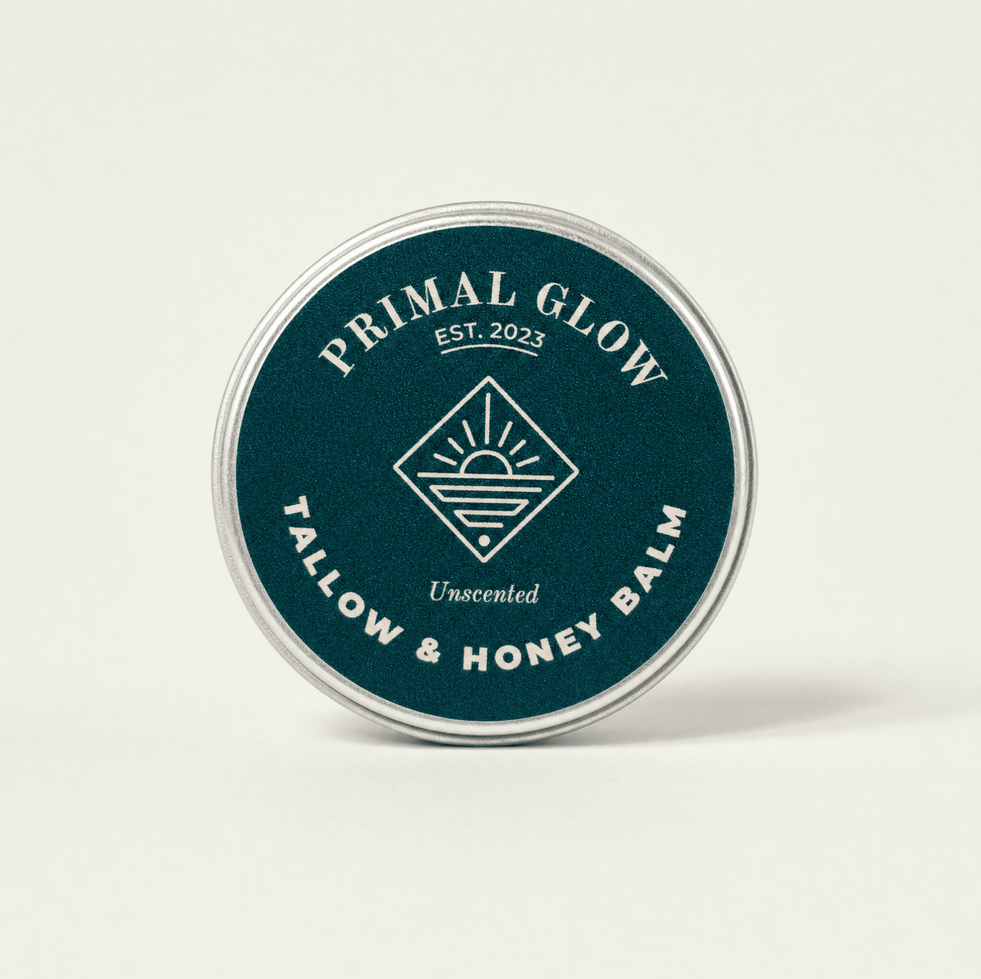 Bovenaanzicht van de Primal Glow tallow en honing hydraterende balsem van 15 ml met zichtbaar logo.