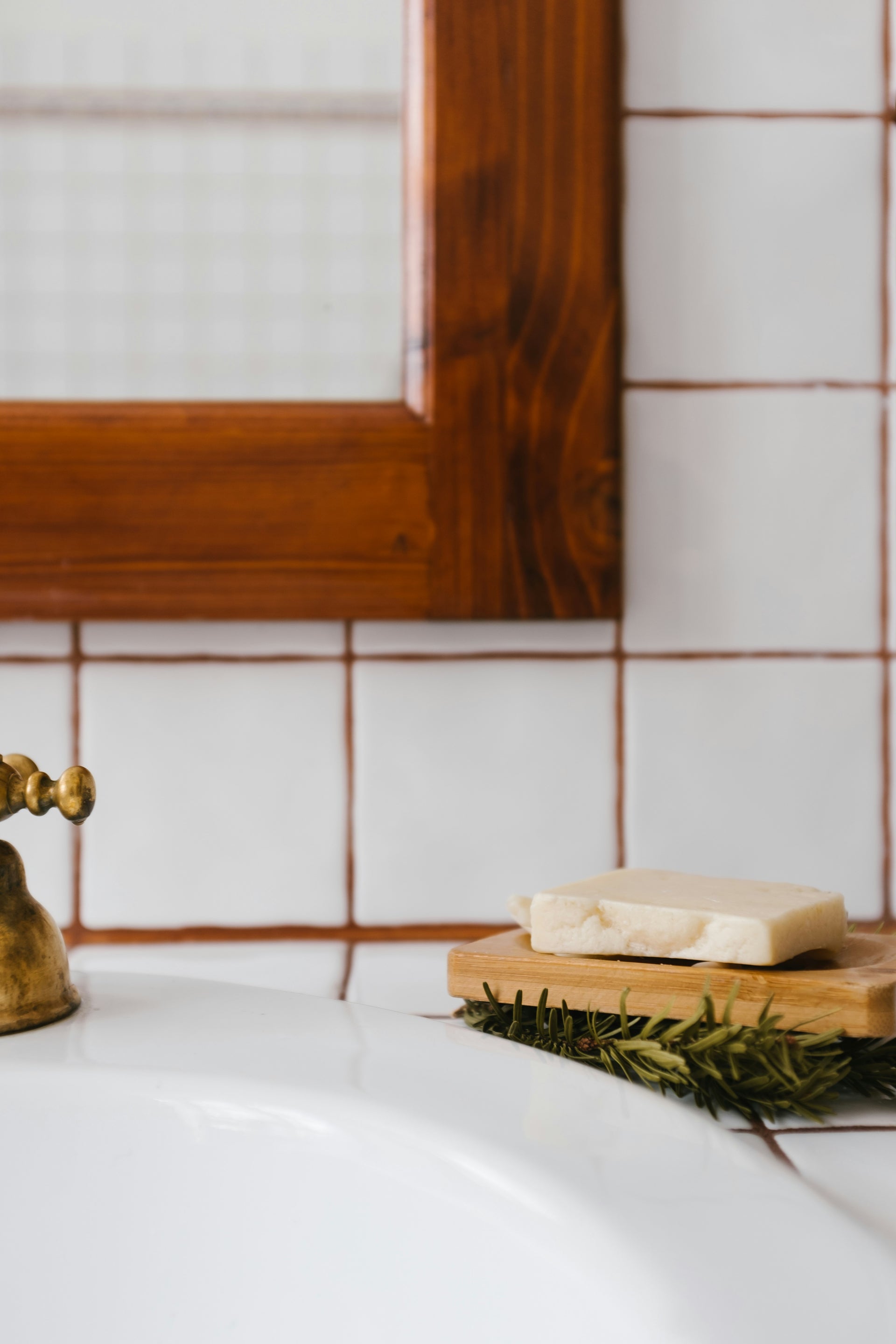 Primal Glow tallow zeep op een houten plankje in een natuurlijke badkameromgeving.