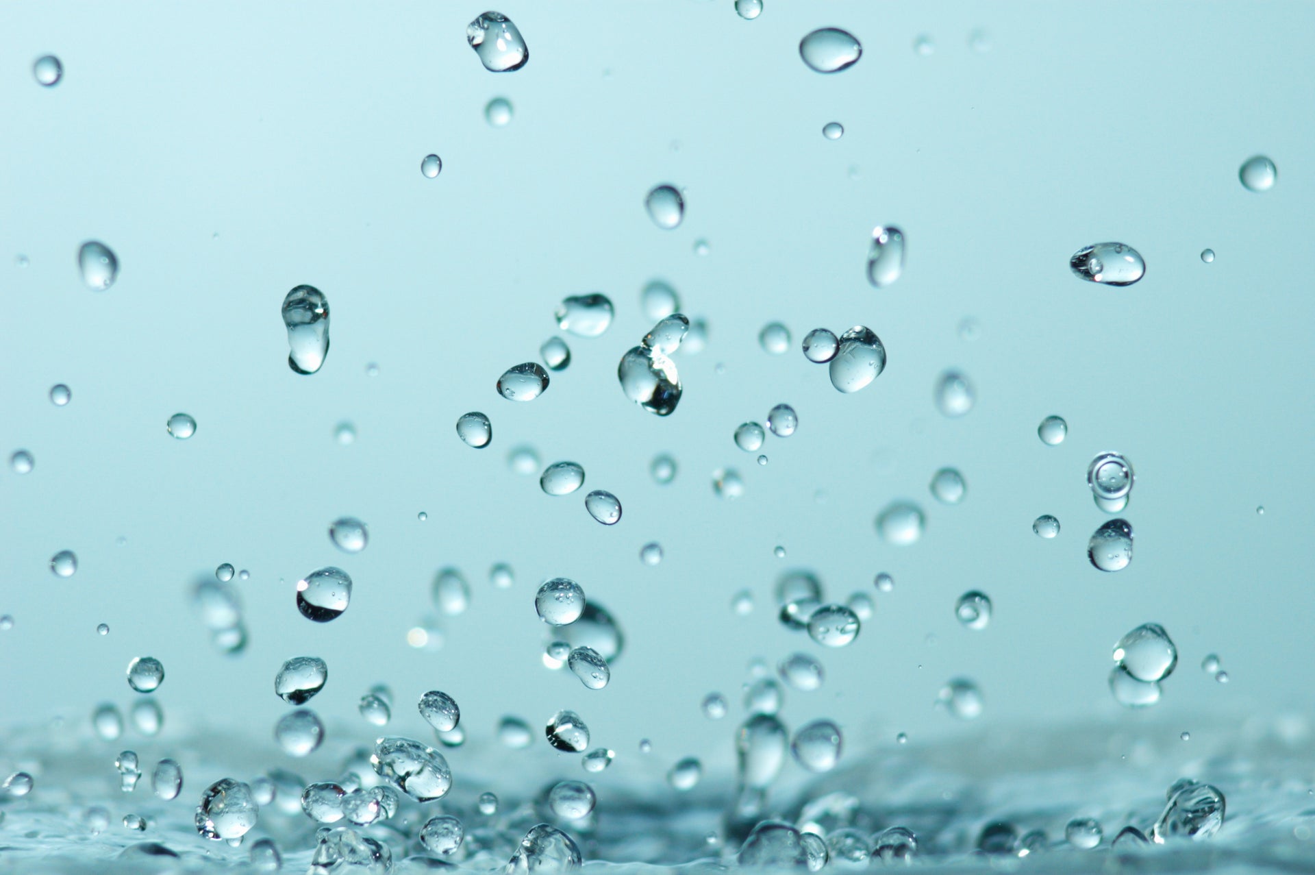 Close-up van waterdruppels op een blauwe achtergrond.